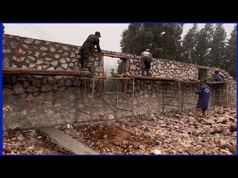 Skilled workers build new houses, fences and beautiful large stone fish tanks