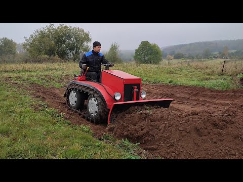 Crawler mini tractor testing snow plow.