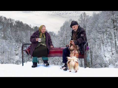 Happy old age of an elderly couple in a mountain village in winter far from civilization