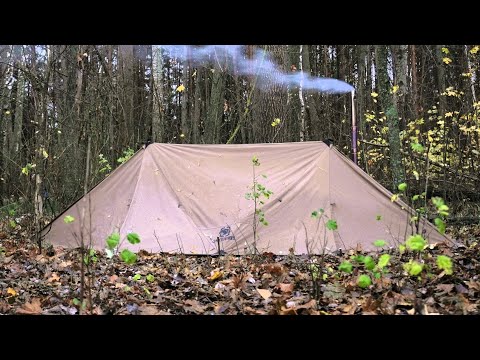hiding in hot tent from the rain on ice river , bushcraft survival camping
