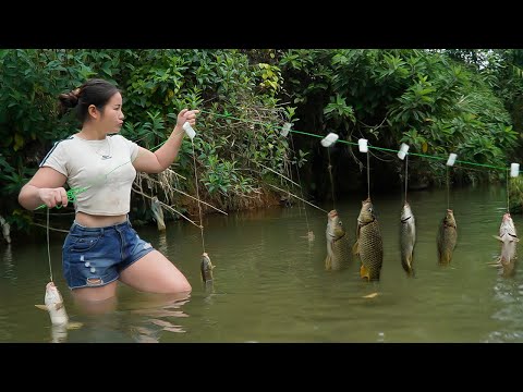 The girl caught many stream fish with a hook and bamboo basket.