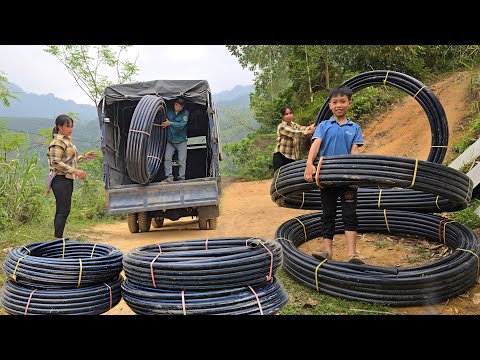The woman uses plastic pipes to carry water from the high waterfall to her house for daily use.