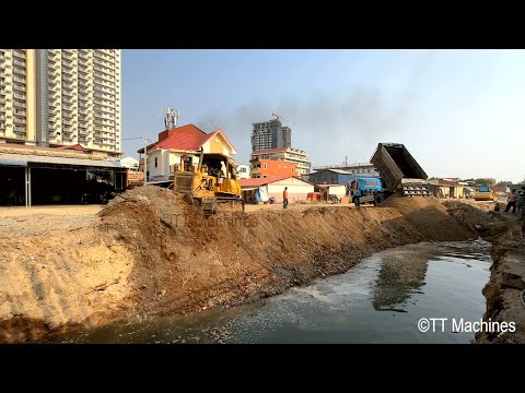 Updating Process Bulldozer & Trucks Pushing Rock And Sand Into Water Making Foundation Village Road