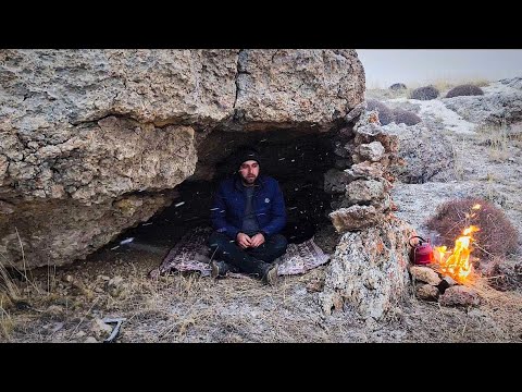 Building a strange and safe shelter in the heart of large rocks. Survival camping in the mountains