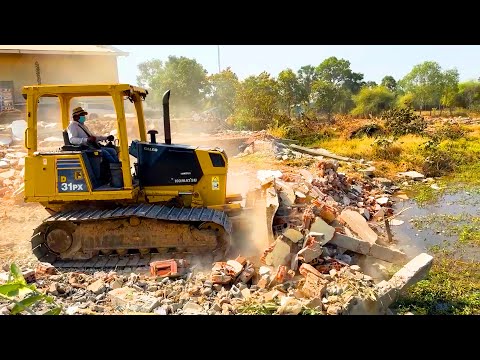 Bulldozer KOMATSU D31PX Pushing concrete Stone to water, Dump Truck unloading