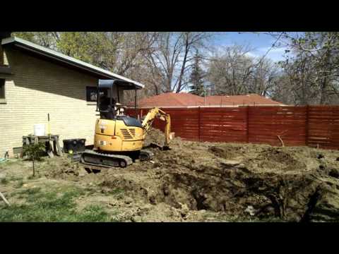Digging a small foundation hole with a rented excavator