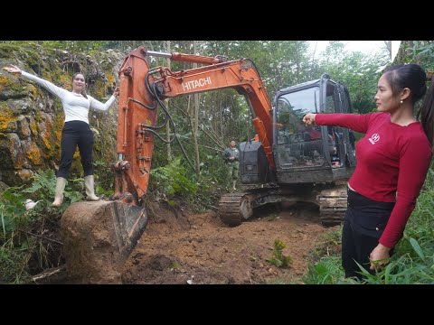 Female engineer lead the excavator dig the ground to opening a path into the deep forest