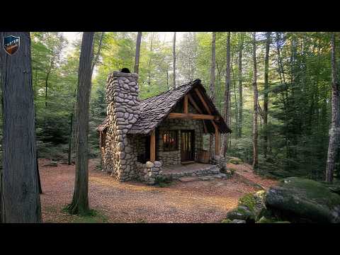 The Hand-Built Wooden House With A Strikingly Tall Stone Chimney By A Man
