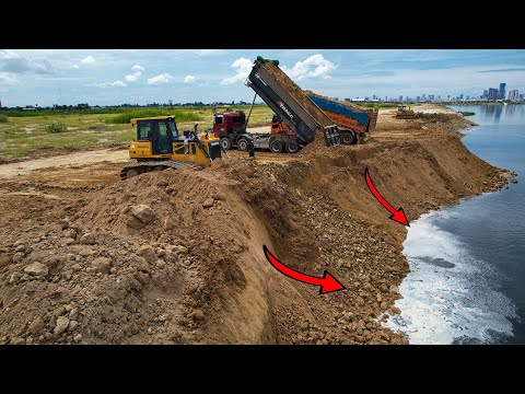 Processing Dump truck 25.5T unloading soil with Dozer KUMATSU Pushing Soil drop into water