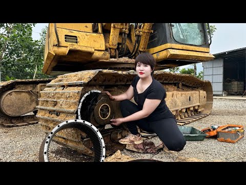 Girl repairs broken Komatsu PC200 excavator brought by machine transport vehicle