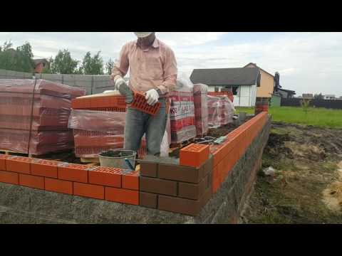 Процесс кладки облицовочного кирпича.