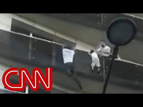 Man scales building to save dangling child