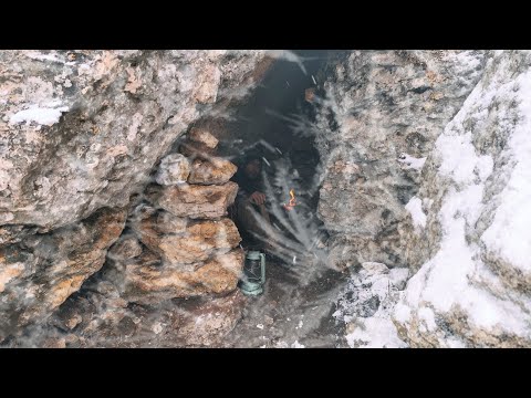 Being caught in a severe blizzard and cold. Building a warm shelter under a rock in harsh conditions