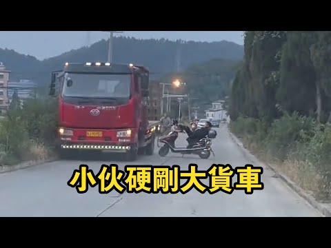 The young man parked his electric bike across the road and showed off his power to the truck!