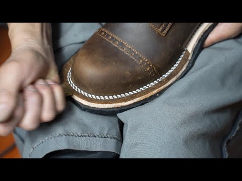 The process of making handmade work boots. Hands of craftsmen who make handmade shoes all their live