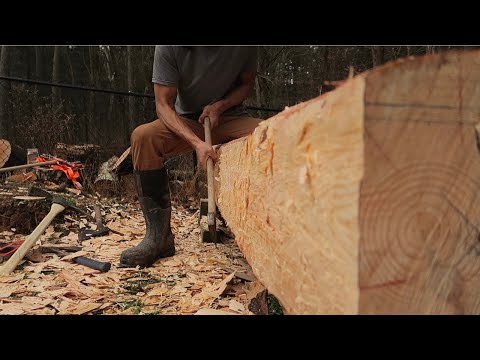 Hand hewing a log