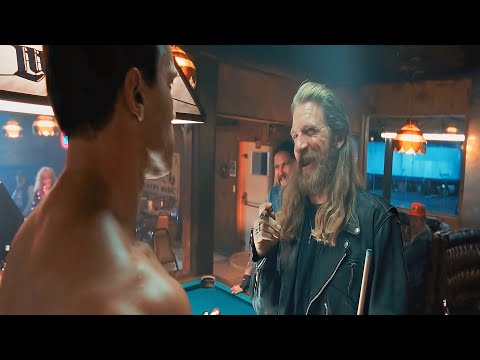 A tough-looking biker puts his cigar out on a new patron’s chest, not realizing he's confronting a..