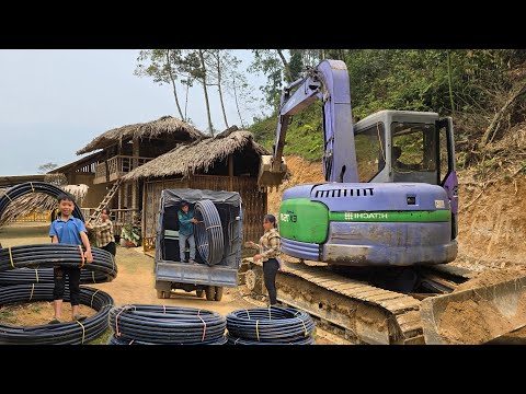 Woman hires excavator to dig around her house, using plastic pipes to bring water for daily use.