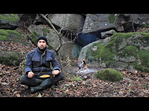 Cooking on a campfire under the rocky shore of a mountain river, wild nature, fire and relaxation