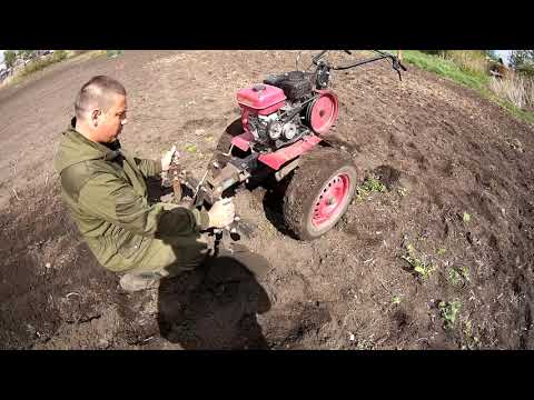 An OKA walk-behind tractor with a double hiller on the front linkage. Planting potatoes.