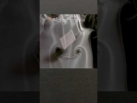 Flying playing card through smoke in slow motion