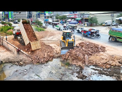 The New Project Bulldozer SHANTUI Clearing Land And Push Stone In Water With DumpTruck Unloadind Sto