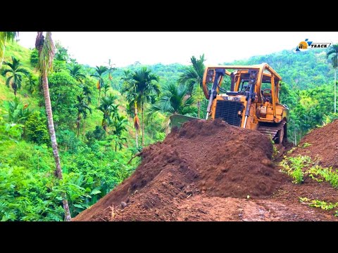 Extreme!! The D6R XL Bulldozer forms a new road by cutting a hillside at the edge of a ravine