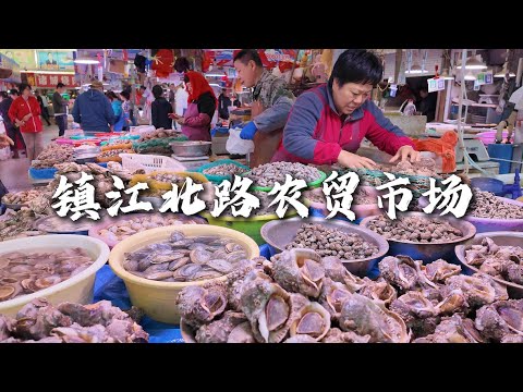 青岛镇江北路繁忙的农贸市场，品种繁多的海鲜、焦香四溢的炸鲅鱼、刚出炉的道口烧鸡，还有崂山的大小樱桃、新鲜的草莓等等。A busy farmers' market in Qingdao