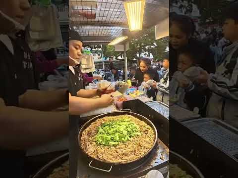 A breakfast stall run by a couple in Guangxi, serving fried rice noodles,chow mein,and egg pancakes