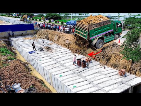Drainage Construction!! A Dump Truck unloading Soil rock to fill concrete pipe with Dozer pushed