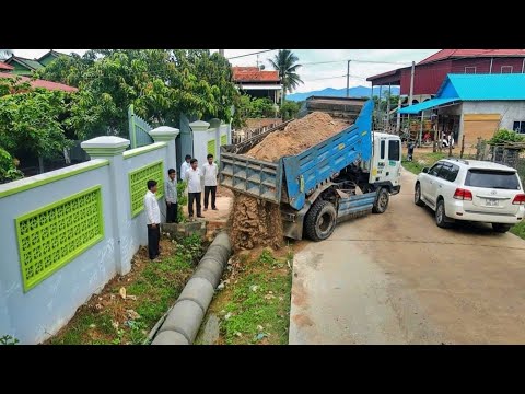 Dropping soil to bury drainage next to the concrete roads and clearing trash behind the house