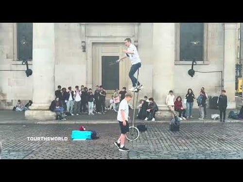 Man Rides Giant Bike While Balancing Sticks – Incredible Street Performance!
