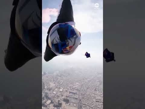 Wingsuit flyers perform daring between-tower stunt