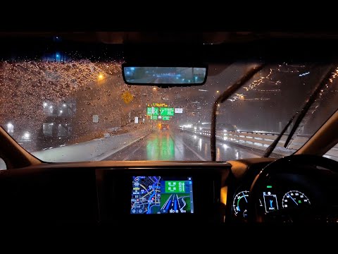 Driving on the highway late at night in heavy rain