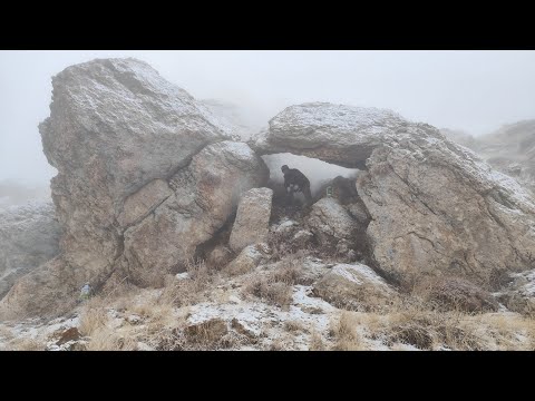 Being caught in a severe blizzard and cold. Building a warm shelter under a rock in harsh conditions