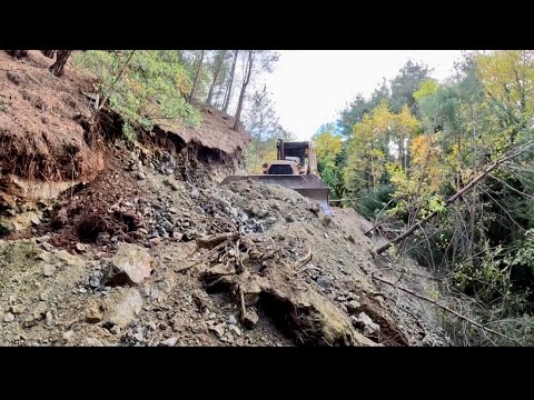 THE LOWER PART OF THE ROAD CONSTRUCTION INVOLVES A CLIFF AND A VERY NARROW FOREST ROAD WITH ACTION