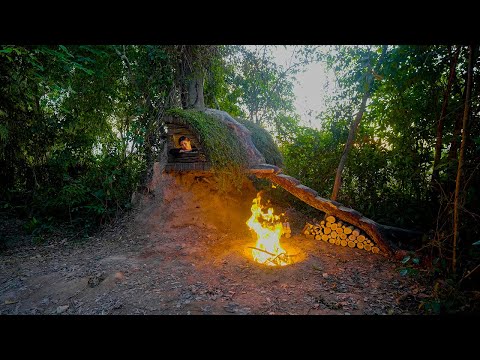 Young Girl Builds a Survival Bushcraft Shelter Under Fallen Tree With Grass Roof in Forest