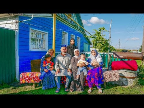 How do large families of Tajiks who came to Russia live in a village?