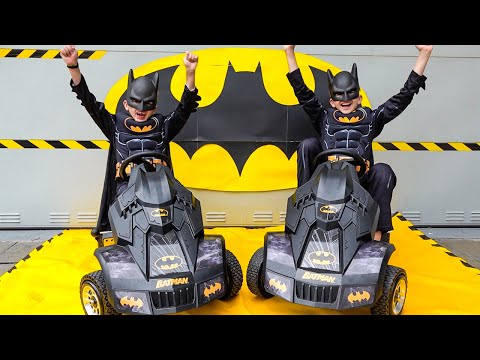 Vlad und Niki geben vor, Batman zu sein und spielen mit Batman-Spielzeug